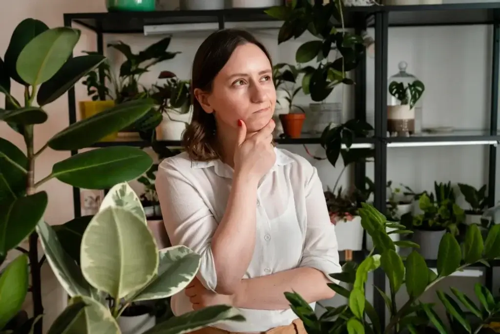 Woman standing in front of indoor plants, symbolizing holistic and naturopathic wellness.