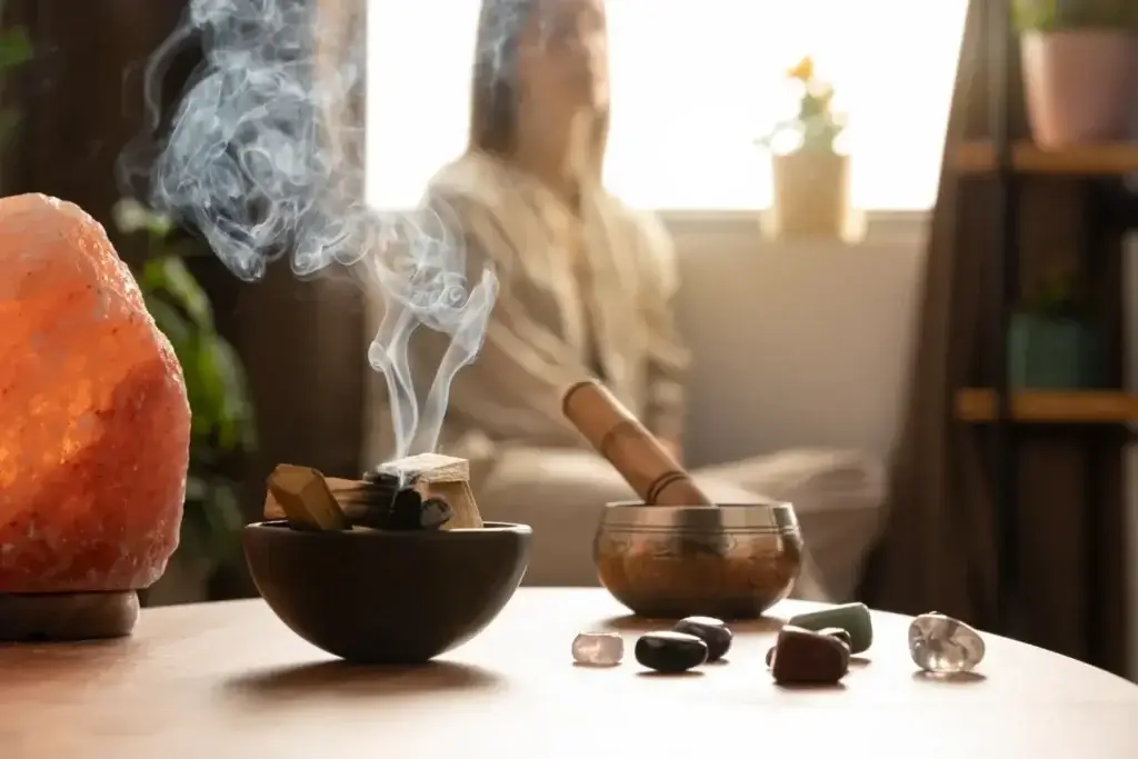 Woman sitting beside incense and a rock, symbolizing calm and holistic wellness in Nanaimo.